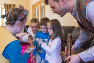 Image shown: Pop Up Picnic visits a family home in Kildare in 2017 with performer Niamh Lawlor and musician Thomas Johnston. Photo credit: Brian Cregan.
